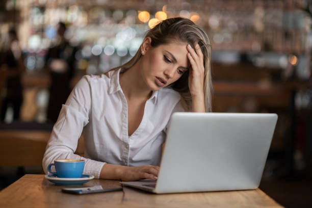 istock Worried businesswoman using laptop in cafeteria 1154782073