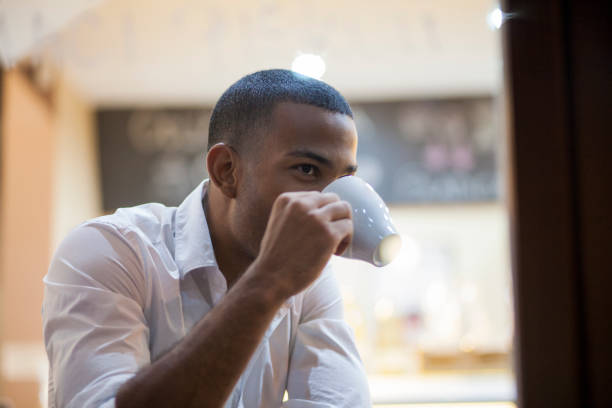istock Young afro-american man drinking coffee in coffee shop 1154782332