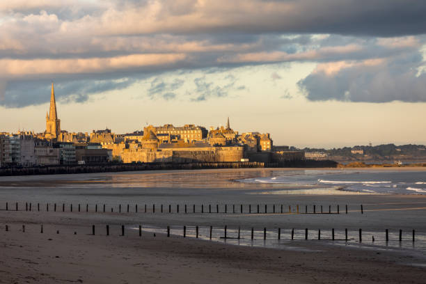 la lumière du matin sur la plage du sillon et la ville fortifiée. saint malo , france, ille et vilaine, côte d'émeraude - beach sunrise waterbreak sea photos et images de collection