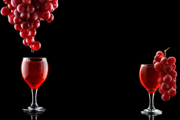 Wine glass and red grapes with drops on blak backgound. Space fot text menu.