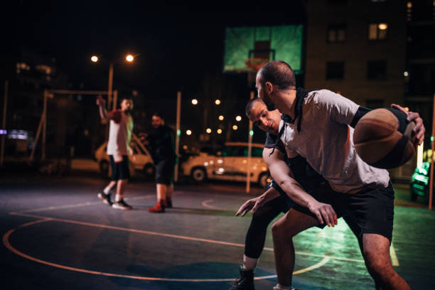 istock Playing basketball game at night 1154784731
