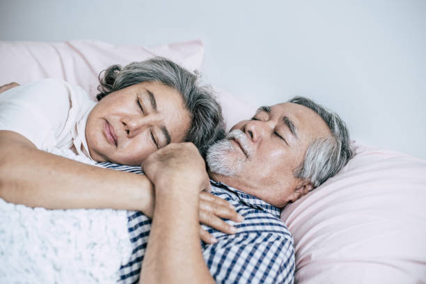 Senior couple lying in bed together stock photo
