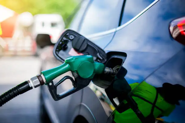 Photo of Hand refilling the white pickup truck with fuel at the gas station