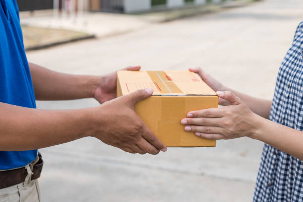 istock Women hands receiving package from delivery man. 1154787199