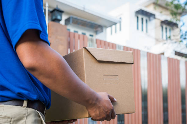 istock Deliver man in blue uniform and parcel cardboard box 1154787316