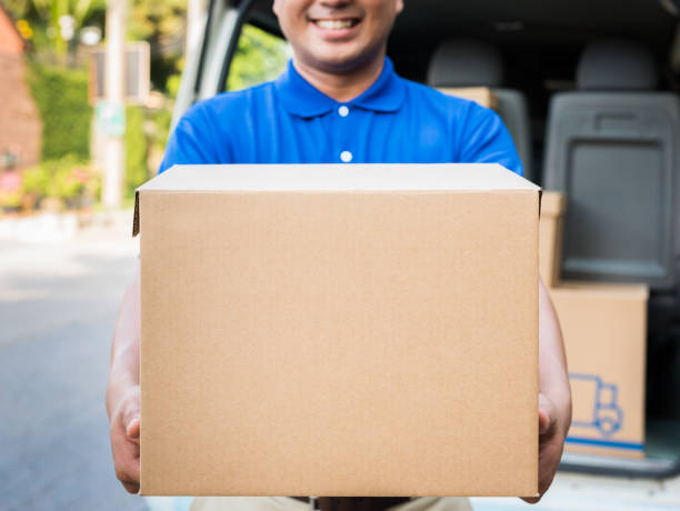 istock Deliver man in blue uniform and parcel cardboard box 1154787320
