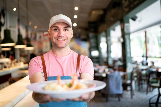 istock Male chef holding prepared dish at restaurant 1154787466