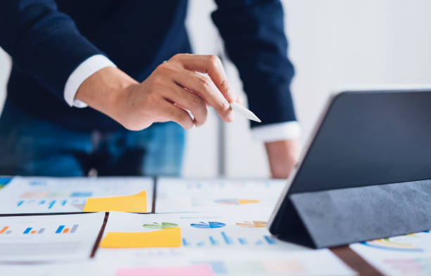 istock Businessman pointing digital pens to tablet and working on the table and  financial documents in office. successful workplace strategy. 1154789524