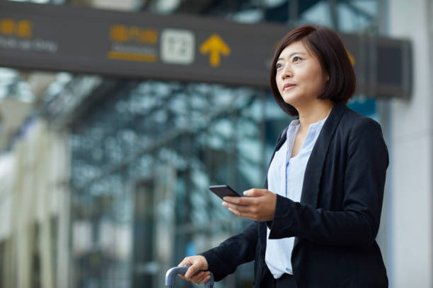istock Female white collar worker looking away at airport 1154789975