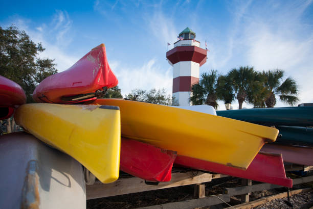 Kayaks in Front of Hilton Head Marina Lighthouse horizontal photograph of kayaks and the lighthouse in Hilton Head, South Carolina hilton head stock pictures, royalty-free photos & images