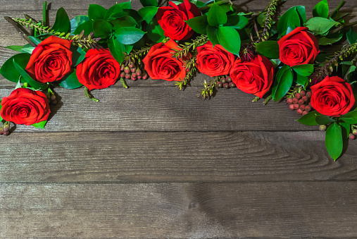 A bunch of beautiful roses laid out at the top of the table. Under the roses is a place for text.