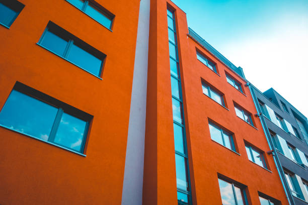 istock modern orange apartment building with glass staircase 1154794497