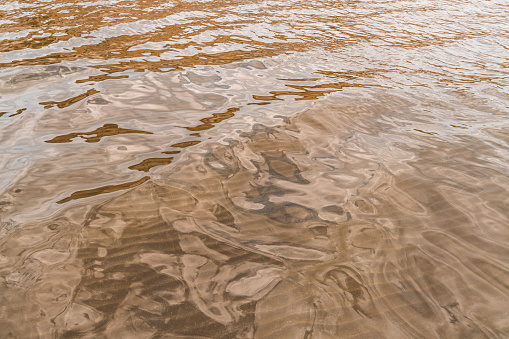 Smooth water surface with sand bottom