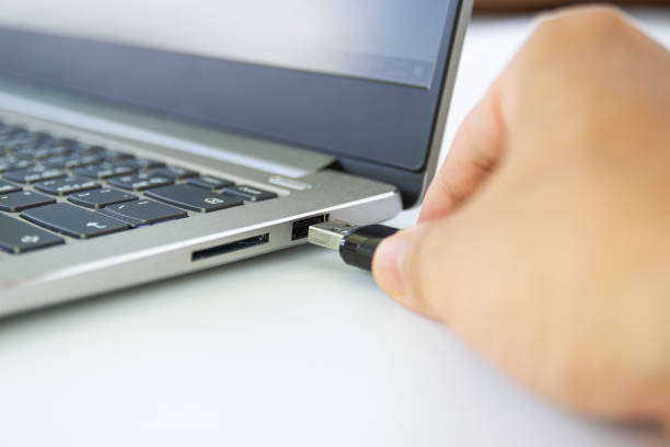 istock hand man hold Flash drive connect to USB port plug-in computer laptop 1154797654