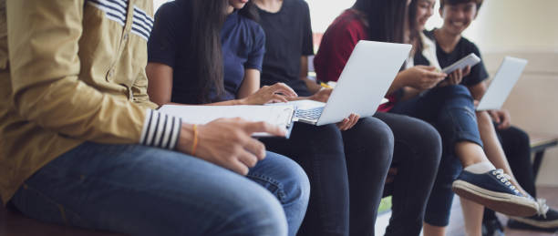 de volta ao conceito da universidade da faculdade do conhecimento da instrução da escola, povos novos que são computador e tabuleta usados, instrução e conceito da tecnologia. - registo no computador - fotografias e filmes do acervo