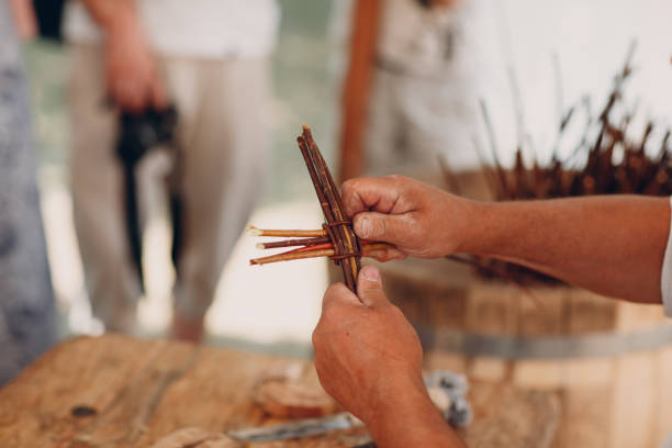 istock Master man weaves a basket of twigs 1154799742