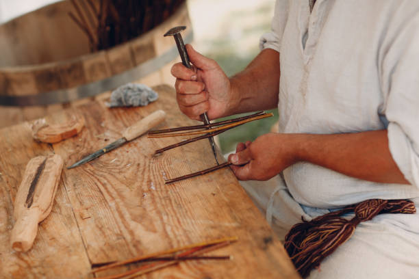 istock Master man weaves a basket of twigs 1154799743