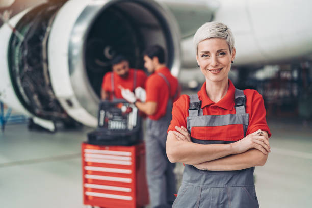 Female airplane mechanic Portrait of a smiling woman airplane mechanic in the hangar airplane maintenance stock pictures, royalty-free photos & images