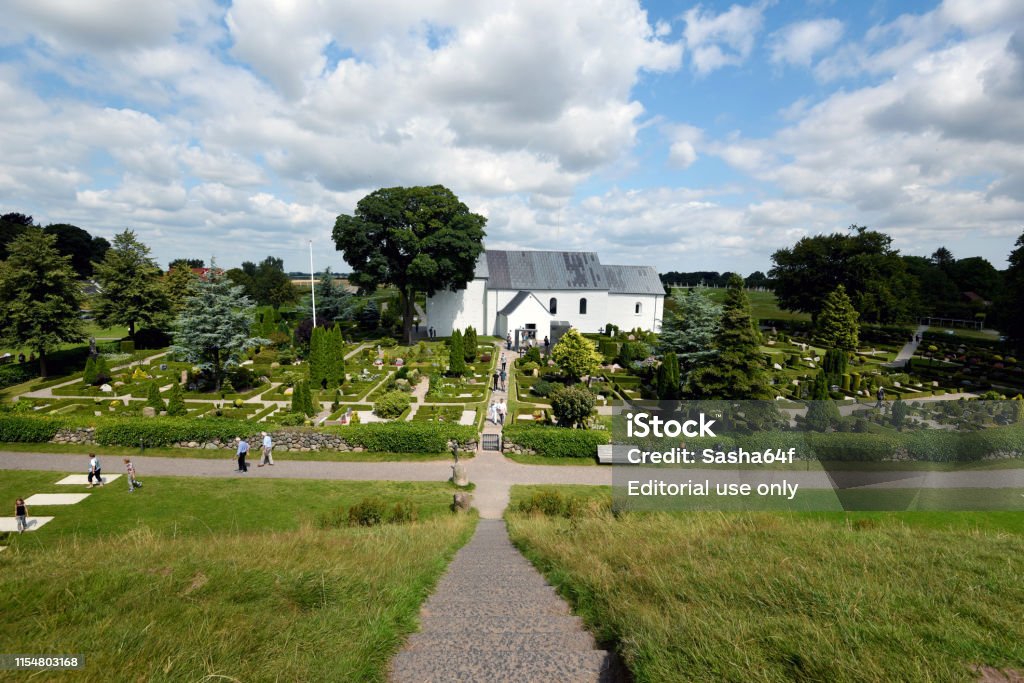 Personnes visitant le site historique de Jelling vu de la colline de Horms. Les pierres runiques de l’âge Viking situées en face de l’église. - Photo de Vejle libre de droits