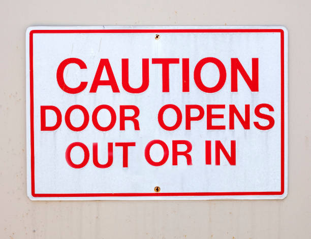 istock CAUTION DOOR OPENS OUT OR IN Sign 1154803658