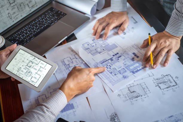 建設工学や建築家は、図面やスケッチの情報をチェックしながら、青写真を議論, パートナーの建築プロジェクトのための会議 - house plan real estate planning ストックフォトと画像