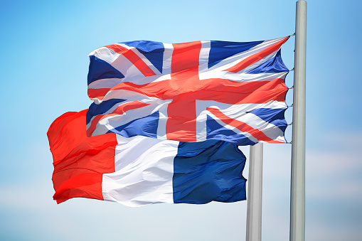 The British and French flags against the background of the blue sky
