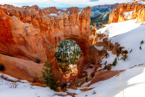 Snow covered canyon looking through a hole in the rock