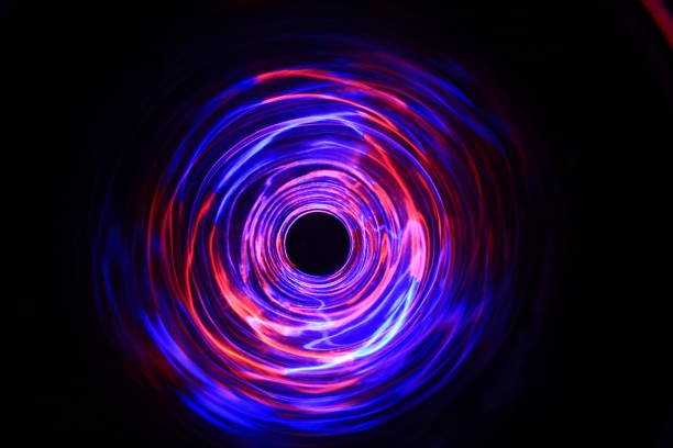 istock LED violet and blue light spinning in the dark. 1154808493