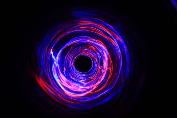 istock LED violet and blue light spinning in the dark. 1154808505