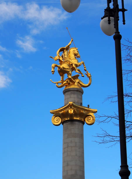estátua dourada de st. george em uma coluna em tbilisi - st george dragon mythology horse - fotografias e filmes do acervo