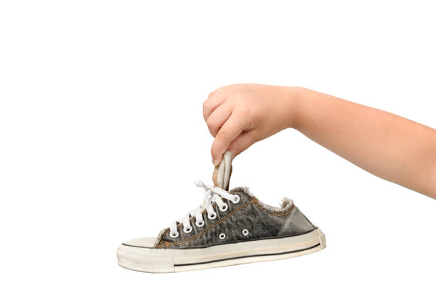 istock Child Holding An Old Dirty and Smelly Sneaker 1154808946