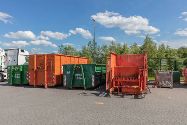 orange waste compactors are standing on a factory site with other waste containers next to them orange waste compactors are standing on a factory site with other waste containers next to them compactor photos stock pictures, royalty-free photos & images