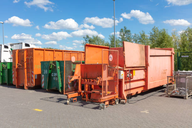 istock orange waste compactors are standing on a factory site with other waste containers next to them 1154812182