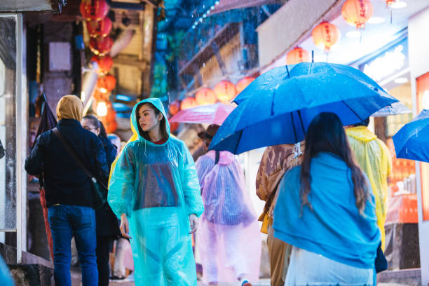 台湾九份での大雨の中で楽しむ若い女性たち
