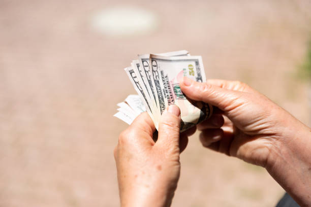 istock Unrecognizable mature female holding US Dollar bills 1154817247