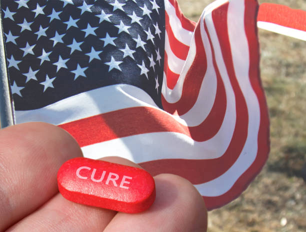 istock Red pill, a pharmaceutical drug with US flag on background. 1154822568