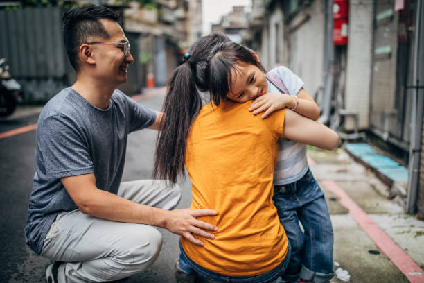 istock Parents hugging daughter before school 1154828774