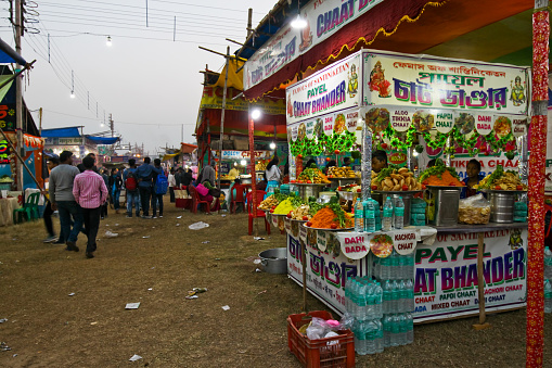Bolpur WB India - December 22, 2018 : Taken this picture in the small town of Bolpur of the annual fair near world famous Shantiniketan of Rabindranath Tagore. In the picture are makeshift shops are setup in hundreds and selling goods and food. In the picture is a cart decorated and selling fast foods. There are people beside it who came to the fair and walking around.