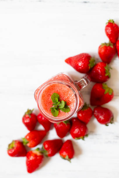 istock Strawberry smoothies or strawberries with ice in a jar. A refreshing summer drink. White background. Top view. Copy space 1154830848