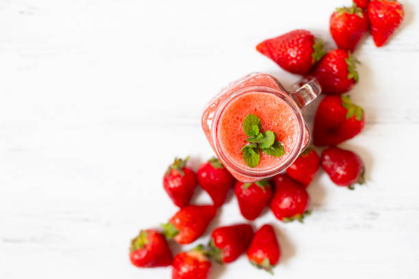 istock Strawberry smoothies or strawberries with ice in a jar. A refreshing summer drink. White background. Top view. Copy space 1154830951
