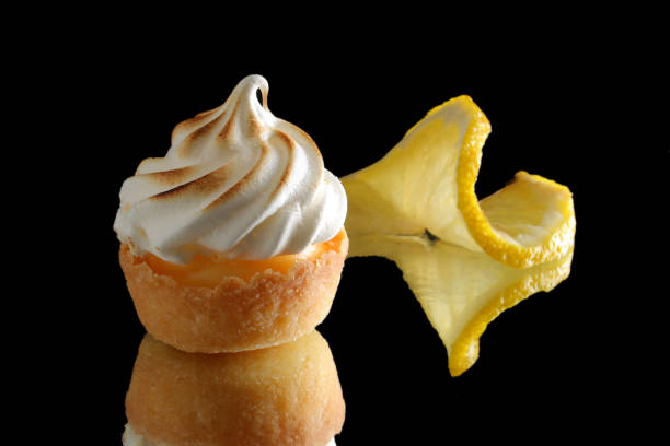 istock Mini lemon meringue tarts on a black reflective background 1154833504