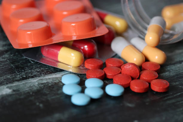 알 약 및 캡슐 어두운 나무 테이블에, 여러 가지 빛깔의 약물 클로즈업의 많은 - capsule pharmacy addiction antibiotic 뉴��스 사진 이미지