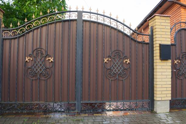 istock brown metal gate with a forged pattern and a brick fence on the sidewalk 1154835341