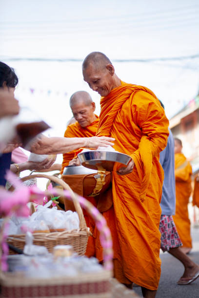 早朝にタイの僧侶に食べ物を提供しているタイの女性 - monk meditating thailand bangkok ストックフォトと画像