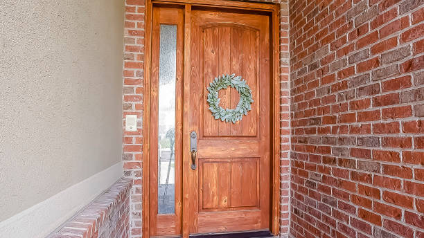 istock Panorama frame Rustic wooden door with wreath sidelight and arched transom window 1154837828