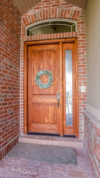 istock Vertical tall frame Rustic wooden door with wreath sidelight and arched transom window 1154837830