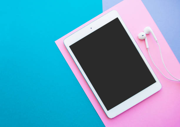 istock Tablet and earphones on bright color background. 1154839314