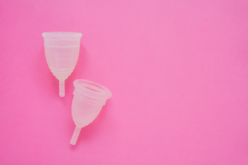 Dos copas menstruales sobre fondo rosado. Producto de higiene femenina alternativo durante el período. Concepto de salud de las mujeres. Copiar espacio photo