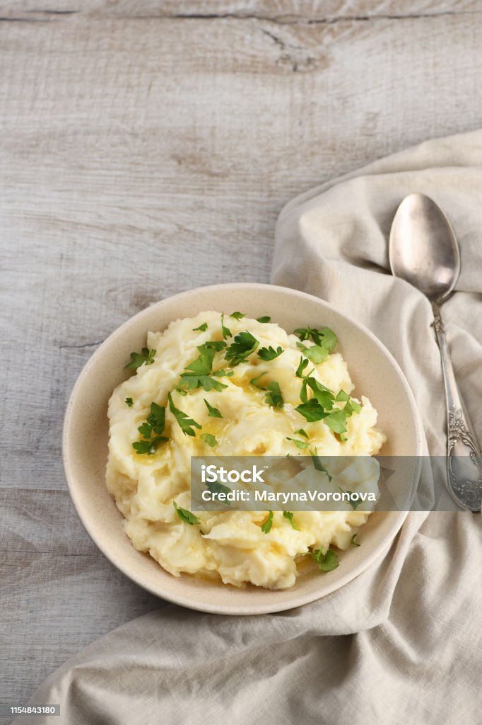 A plate of mashed potatoes poured with melted butter and seasoned with greens Boiled Stock Photo