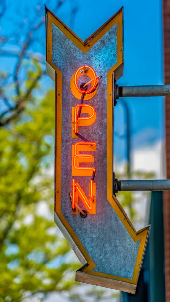 istock Panorama Red brick building with an Open arrow sign viewed on a sunny day 1154845049